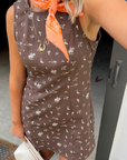 Close-up of Giddy Up Brown Cowboy Print Mini Dress showing western-themed white print and sleeveless design, ideal for casual western wear.