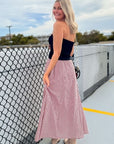 Back view of the Put Me In Crimson Gingham Maxi Skirt showing its flowy silhouette and timeless gingham pattern for gameday style.