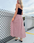 Side-back angle of the crimson gingham maxi skirt styled for fall, showcasing its flattering fit and casual elegance for gameday wear.