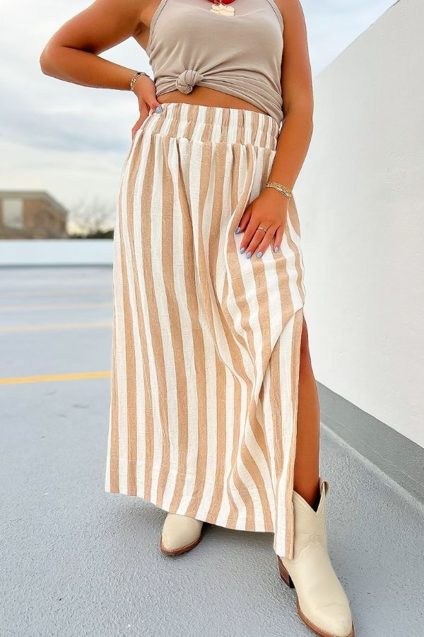 Close-up of Emma Natural Striped Midi Skirt showing beige and white vertical stripes, side slit, and elastic waistband for a flattering fit.