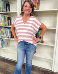 Mauve V-Neck Striped Top with blush and white horizontal stripes, styled with jeans for a casual summer look in a library setting.