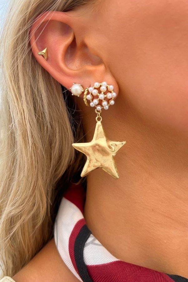 Gold Hammered Star Pearl Drop Earrings featuring a large textured gold star charm and clustered pearl accents, ideal for elegant accessorizing.