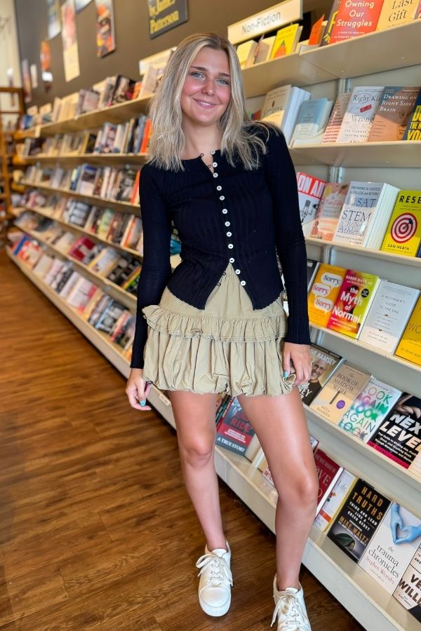 Model wearing Free People Black Tilly Long Sleeve – Slim-fit ribbed top with front buttons, styled for a trendy back-to-school or lounge outfit.