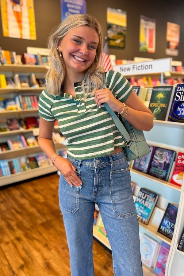 Model smiling in Easy A Green Striped Baby Tee, highlighting the flattering cropped cut and fresh green stripe knit pattern.