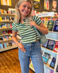Model smiling in Easy A Green Striped Baby Tee, highlighting the flattering cropped cut and fresh green stripe knit pattern.