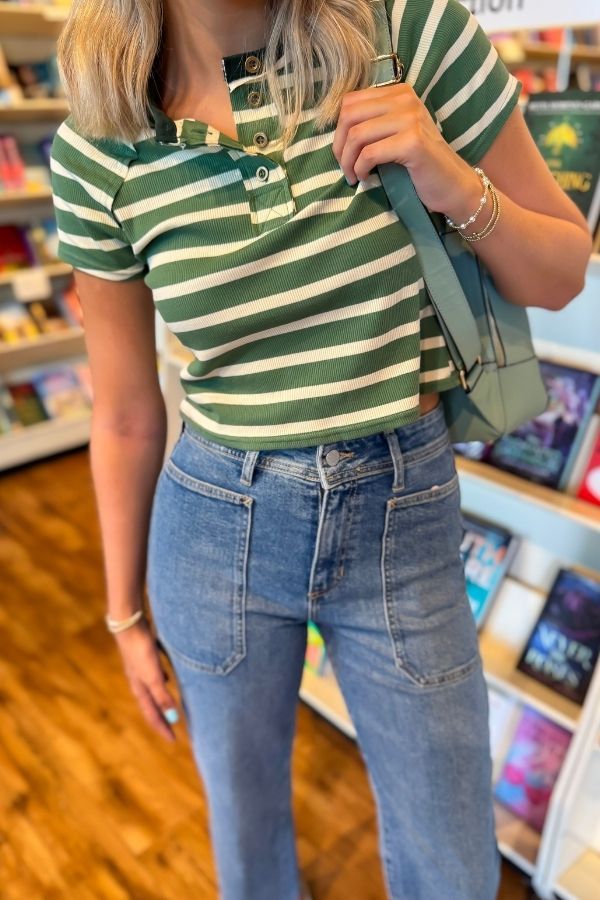 Close-up of Green Stripe Knit Top WM showing ribbed texture, buttoned V-neck, and horizontal stripes for a casual-chic look.