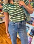 Close-up of Green Stripe Knit Top WM showing ribbed texture, buttoned V-neck, and horizontal stripes for a casual-chic look.