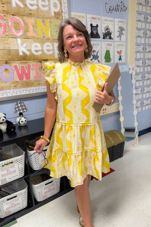 Better In Yellow Ruffle Mini Dress with tiered skirt and flutter sleeves, styled for a cheerful classroom-ready look.
