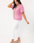 THML Pink Floral Smocked Neck Top with block print design and V-neckline, styled with white cropped pants for a chic spring outfit.