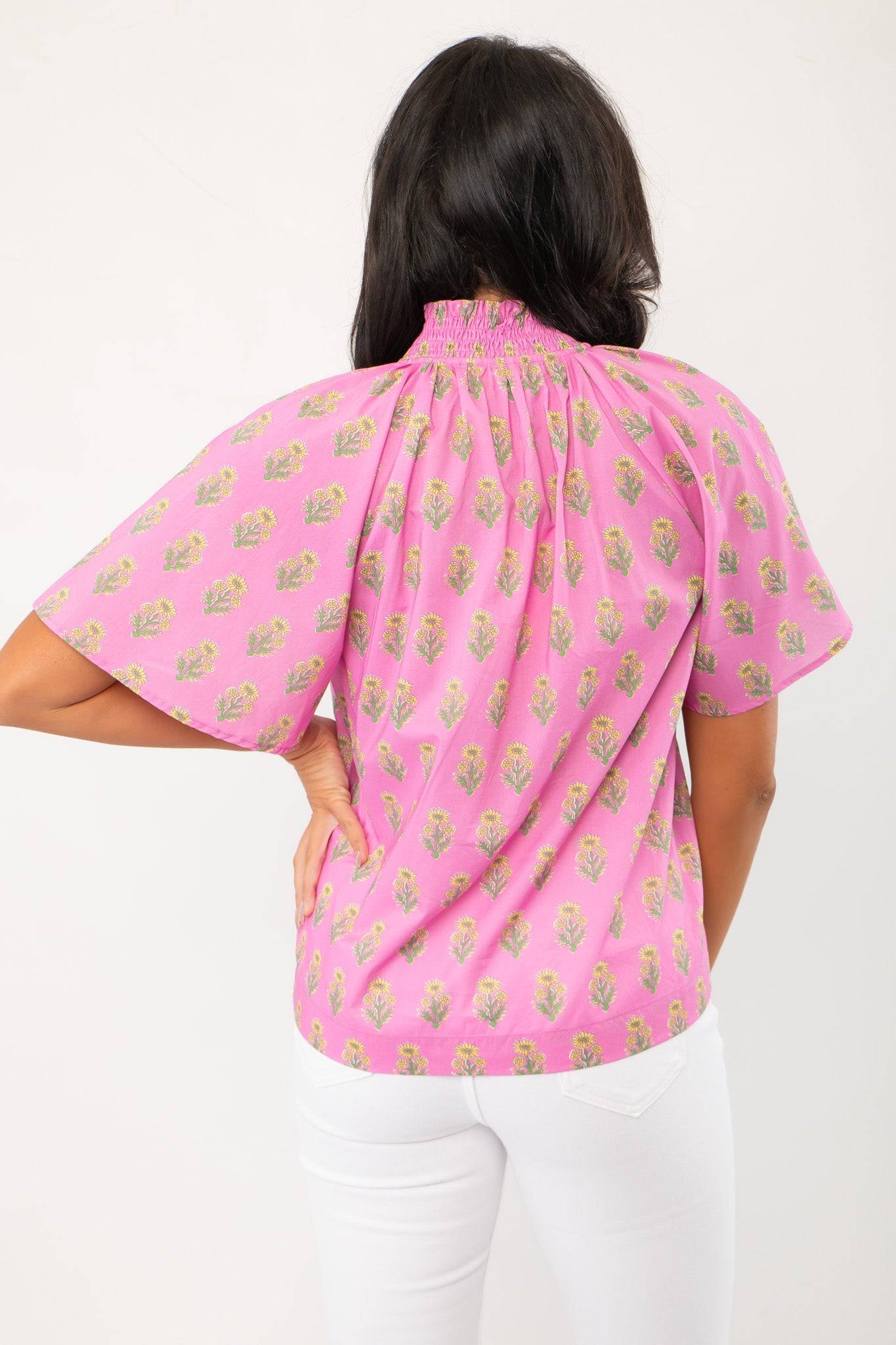 Back view of THML Pink Floral Smocked Neck Top featuring a block print floral pattern and short sleeves, ideal for spring fashion.