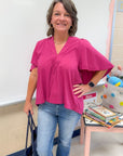 Very Berry Tunic Top - Pinch Pleated in vibrant berry pink with flowy short sleeves and V-neck, styled with jeans for a casual-chic look.