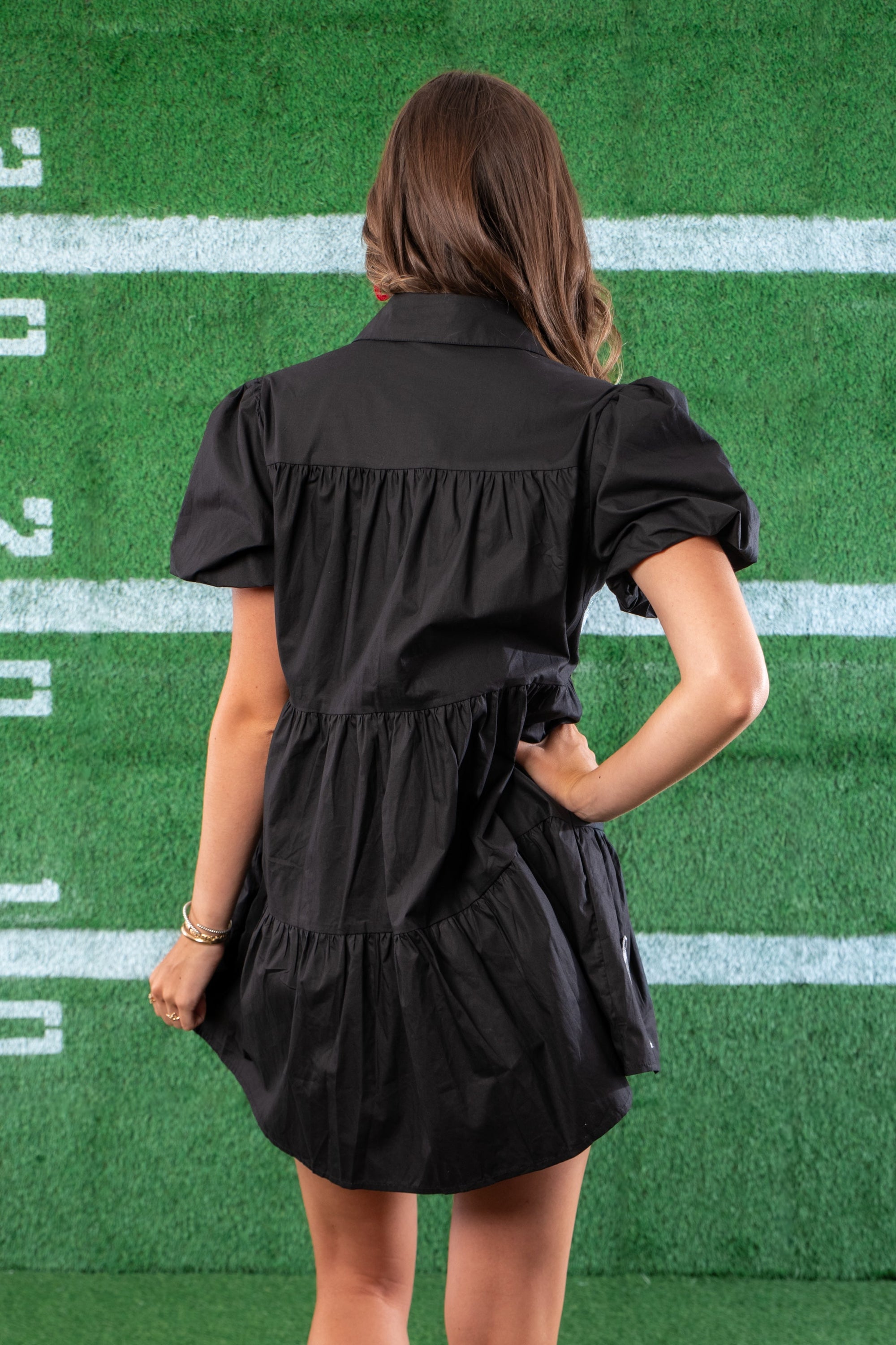 Back view of the Black Sequin Football Dress showcasing its tiered design and puff sleeves, perfect for a sporty yet stylish outfit.
