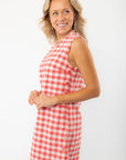Side profile of Poppy Red Gingham Mini Dress with button accents, ideal for showcasing its flattering fit and playful summer vibe.