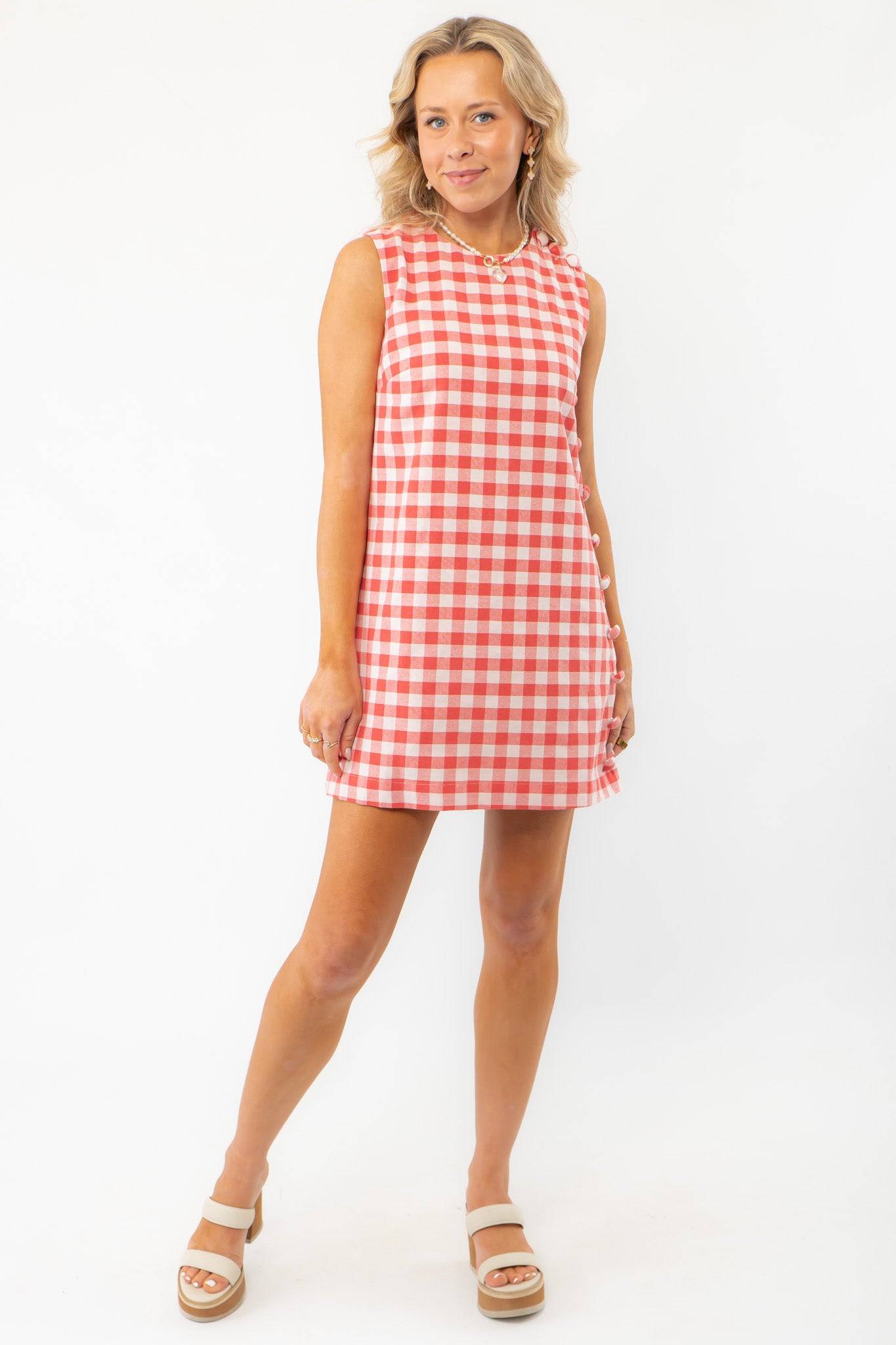 Model wearing Poppy Red Gingham Mini Dress with platform sandals, perfect for casual summer events and daytime outings.