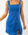 Chic blue mini dress with a bold side bow and flattering square neckline. Designed with a side slit and back zipper for a stylish, sophisticated look.