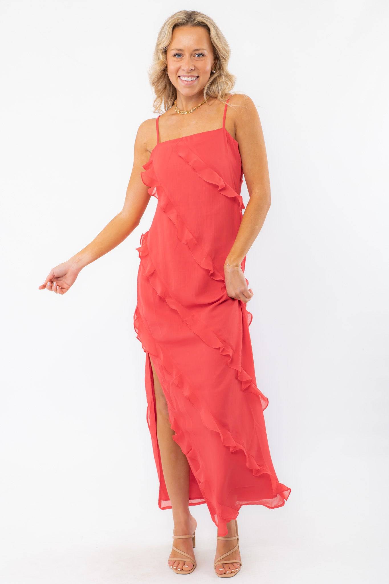 MINKPINK Red Ruffle Maxi Dress styled with nude heels, featuring a bold red hue, ruffle details, and a side slit for a glamorous evening ensemble.