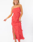 MINKPINK Red Ruffle Maxi Dress styled with nude heels, featuring a bold red hue, ruffle details, and a side slit for a glamorous evening ensemble.