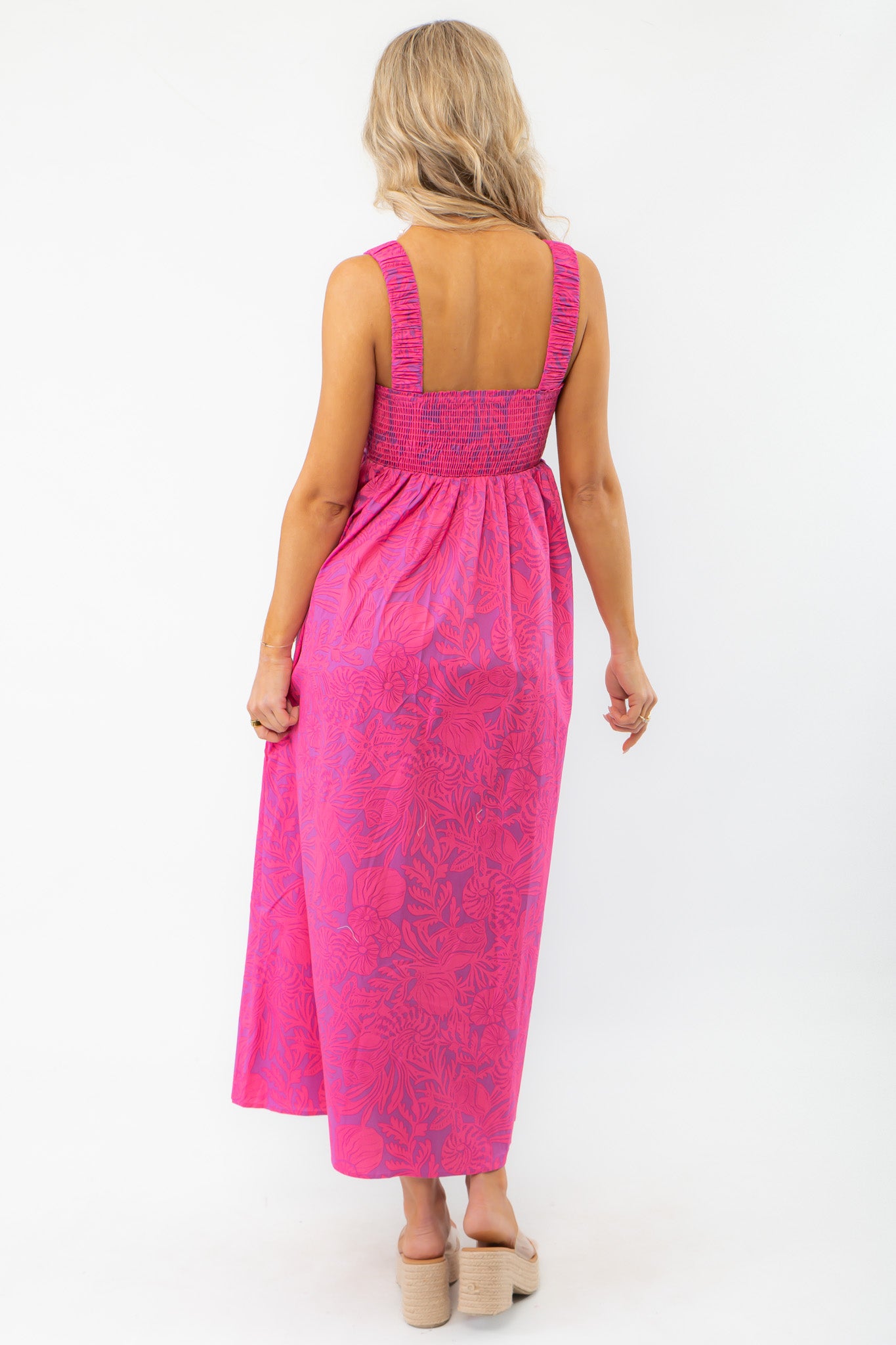 Back view of the Show Me Your Mumu Pink Shells Fling Midi Dress showcasing its smocked back detail and flowy silhouette for a breezy summer look.