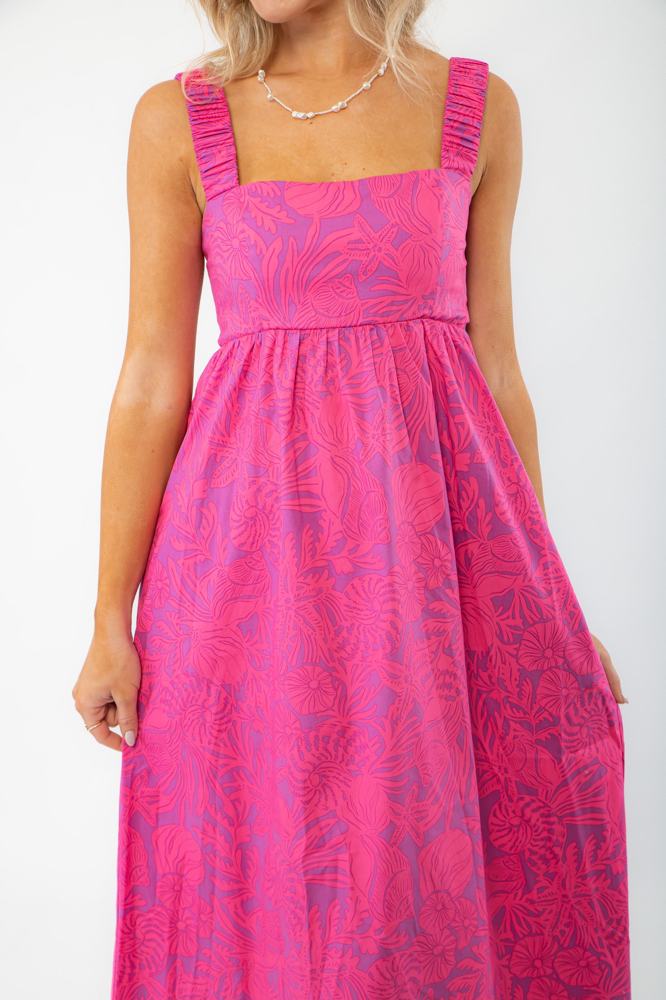 Close-up of the Show Me Your Mumu Pink Shells Fling Midi Dress, showcasing its ruched straps, square neckline, and intricate tropical print.