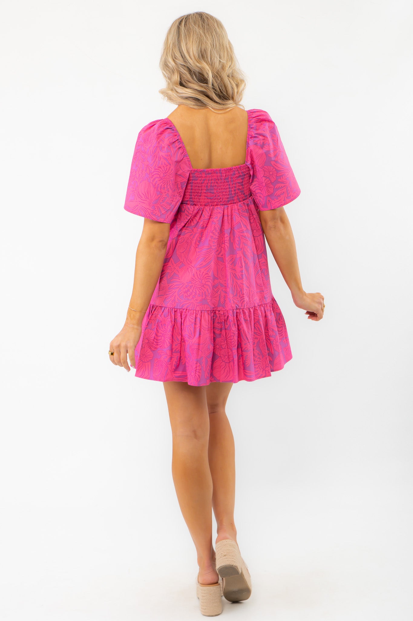 Back view of the Show Me Your Mumu Pink Shells Erin Mini Dress showcasing smocked detailing and a flowy silhouette.