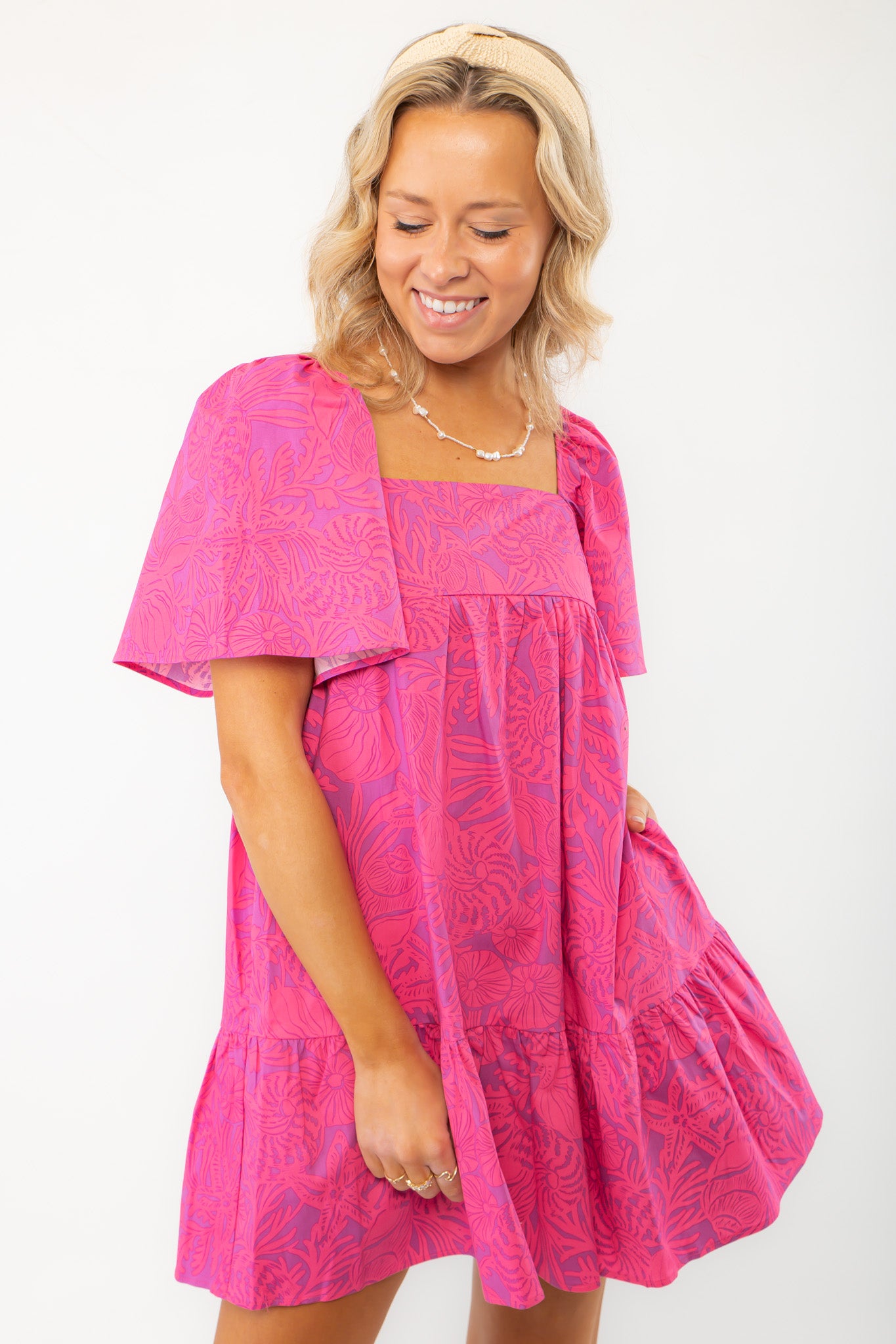Close-up of the Pink Shells Erin Mini Dress highlighting its lightweight fabric, tropical print, and feminine ruffle accents.