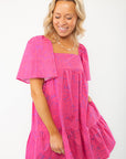 Close-up of the Pink Shells Erin Mini Dress highlighting its lightweight fabric, tropical print, and feminine ruffle accents.