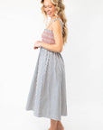 Side view of THML Smocked Blue Striped Tie Strap Midi Dress with tie straps and flared skirt, a stylish choice for vacation or Fourth of July events.