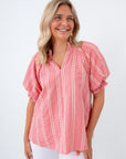 Woman wearing a red and white striped blouse styled for a summer picnic