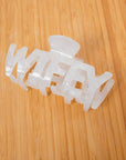 White acrylic Wifey Bridal Claw Clip on wooden surface