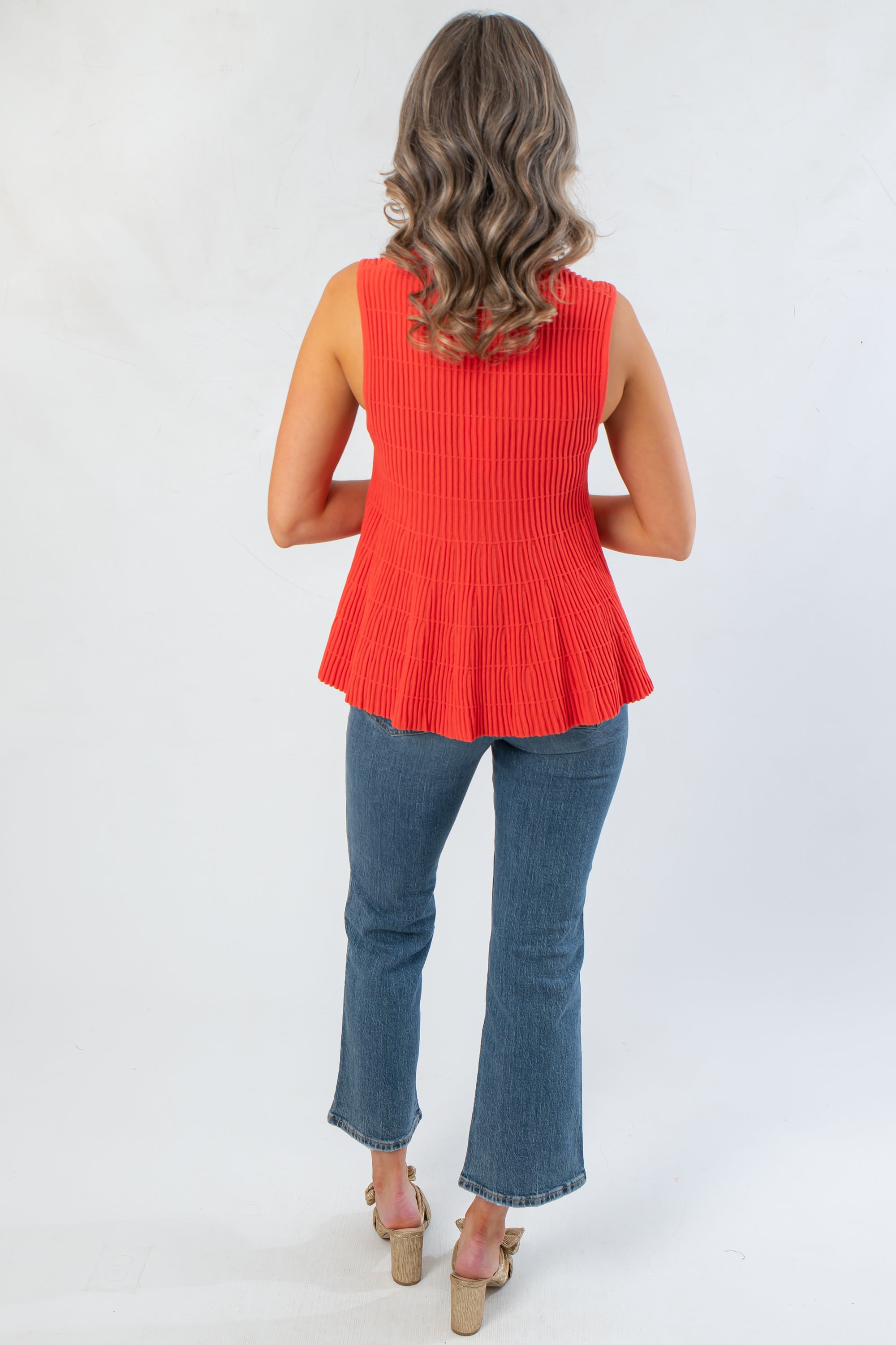 Back view of Papaya Flared Rib Knit Top with ribbed knit texture and flared hem, offering a flattering fit for versatile styling.