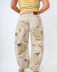 Person wearing a yellow striped top and beige pants with banana pattern on a white background