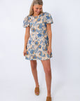 Side view of floral puff sleeve mini dress with blue and beige pattern, worn with tan wedge sandals