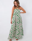 Back view of woman in Show Me Your Mumu Coastal Collage Maxi Dress with green pattern