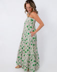 Side profile of woman in Show Me Your Mumu Coastal Collage Maxi Dress with hand in pocket