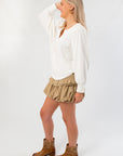 Side view of Free People Ivory Quinn Knit Top showing relaxed fit and long sleeves, ideal for layering in everyday outfits.