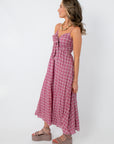 Pink gingham midi dress with spaghetti straps and front tie detail, styled for spring and summer occasions