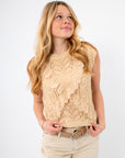 Feminine crochet sleeveless knit top with delicate lace ruffles, styled for casual wear with light neutral pants.