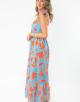Side profile of THML Tie Strap Flower Print Maxi Dress showcasing its relaxed fit and vibrant floral print, perfect for summer travel.
