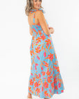 Back view of THML Tie Strap Flower Print Maxi Dress featuring smocked bodice and flowy skirt, designed for comfort and vacation style.