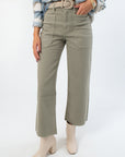 Rosemary Utility Wide Leg Jeans in faded green with high rise fit and front cargo pockets, styled with a woven belt and ankle boots.