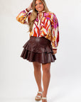 Tanner Burgundy Skirt - Faux Leather Flared Hem styled with a floral blouse, perfect for trendy fall outfits or gameday looks.