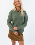 Dark Sage Ribbed Crewneck Sweater with long sleeves and textured knit, styled for fall layering with a brown suede mini skirt.