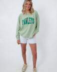 Model wearing green Pawleys Island sweatshirt with white shorts and colorful accessories