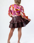 Back view of the Tanner Burgundy Skirt - Faux Leather Flared Hem highlighting its tiered structure and flattering fit.