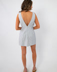 Back view of the Palmetto Pier Blue Stripe Mini Dress highlights its deep V-back cut, adding a stylish touch to this summer mini dress.