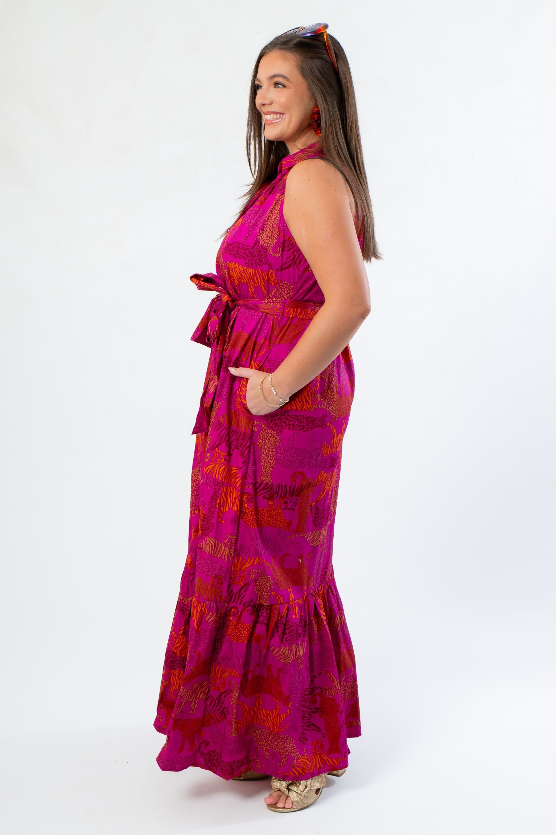 Side profile of Cileah Maxi Dress in magenta jungle print, showcasing sleeveless cut, belted waist, and flared hemline.