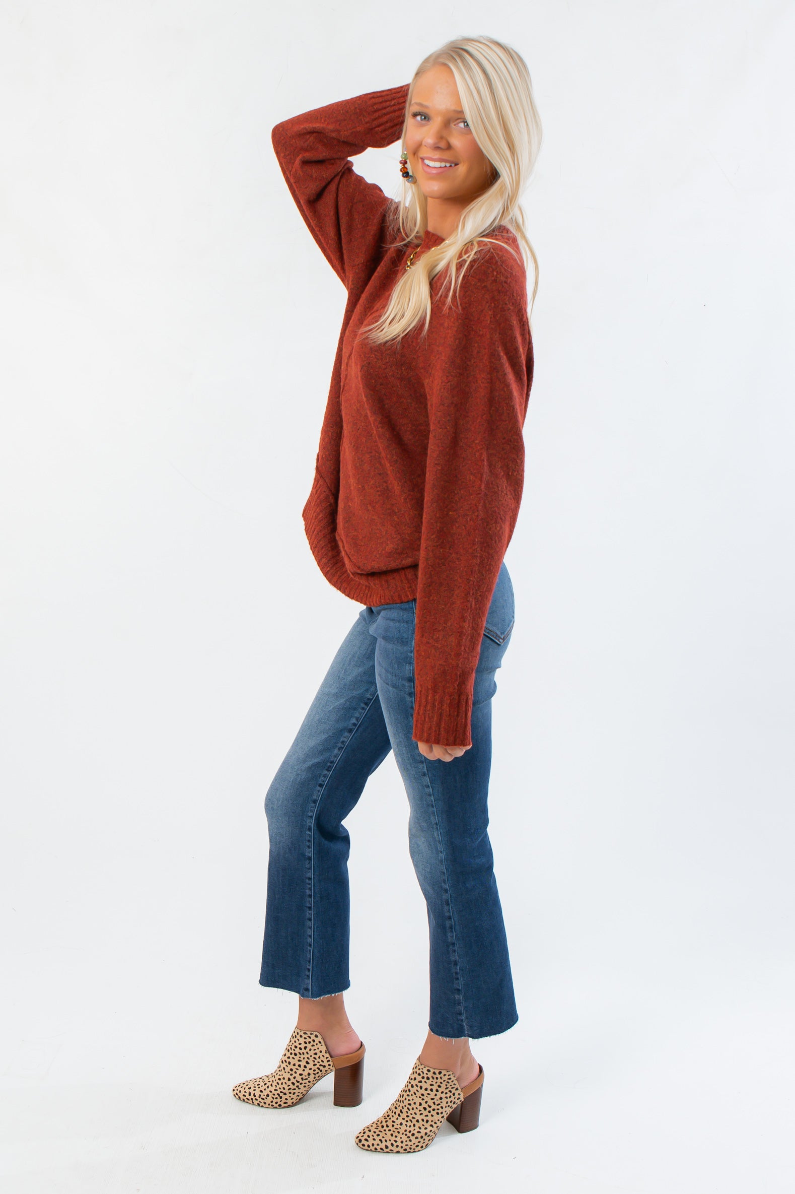 Side view of Take It Easy Rust Pullover Sweater showing relaxed fit and soft knit texture, styled with denim and fall footwear.