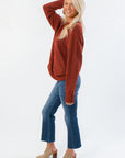 Side view of Take It Easy Rust Pullover Sweater showing relaxed fit and soft knit texture, styled with denim and fall footwear.