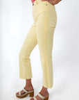Back view of pastel yellow jeans with rear pockets, styled with pink floral top and platform sandals