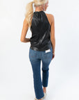 Back view of Black Faux Leather Halter Top with zipper closure and halter neckline, styled with cropped jeans for a trendy finish.